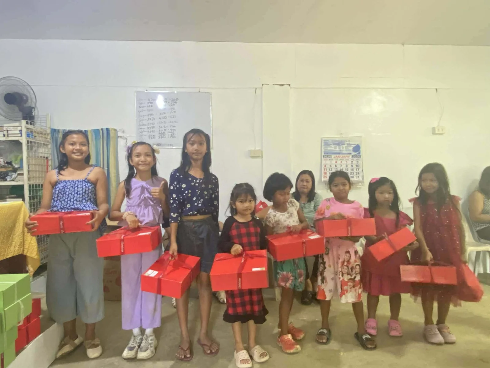 Children and adults standing together with colorful gift boxes