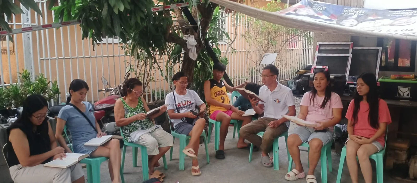 A group sitting outdoors with papers and notebooks