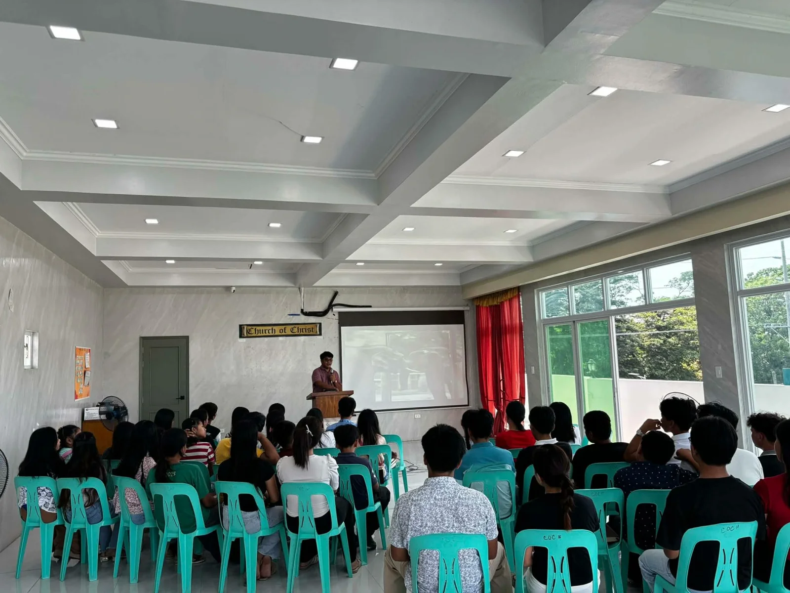 A speaker addressing an audience in a hall